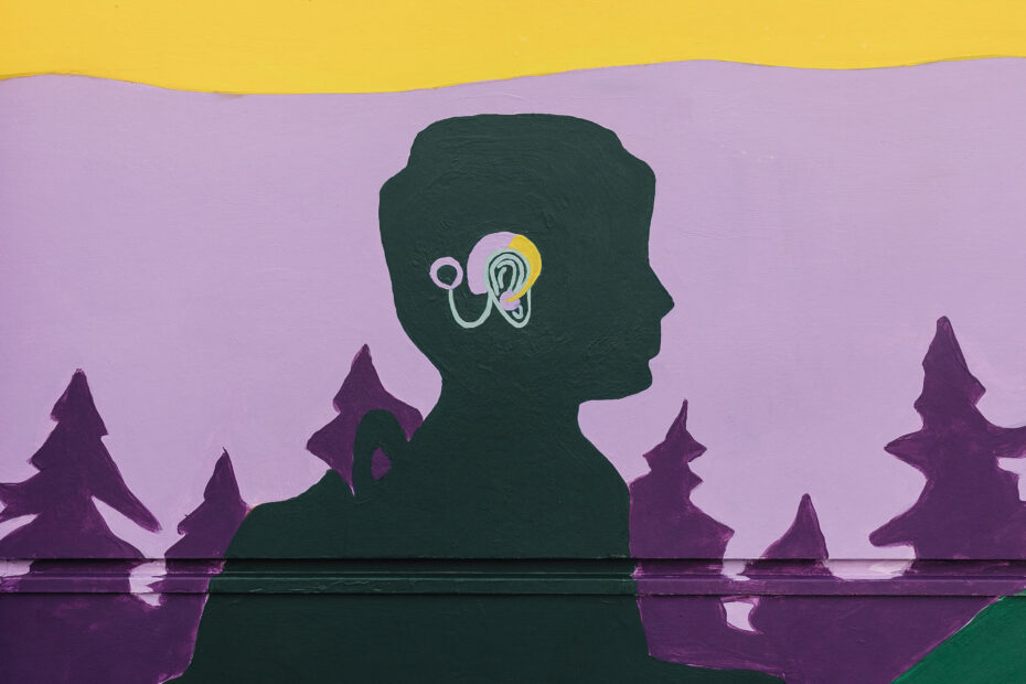 A part of the mural artist Aistė Rye designed for the Northwest school for Deaf and Hard-of-Hearing Children. A close up of a painted silliouette of child with a hearing device in color.